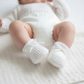 White baby booties worn on baby's feet